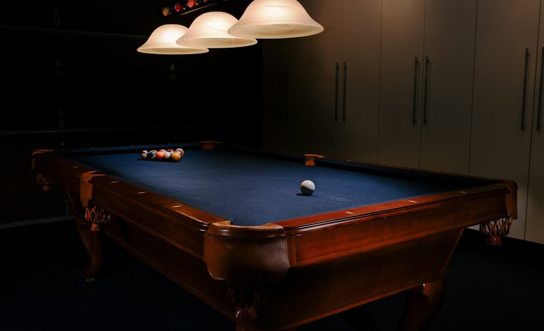 Indoor pool table beneath game-room lighting
