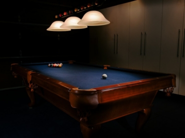 Indoor pool table beneath game-room lighting