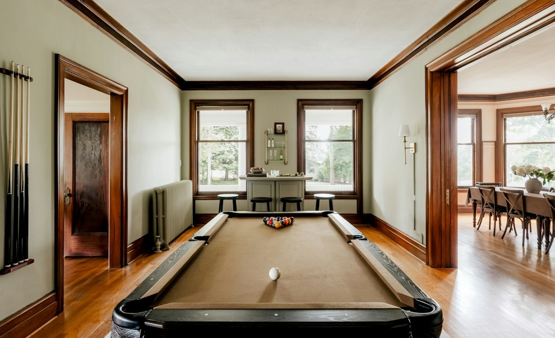 Pool table in a finished home game room with space around the table