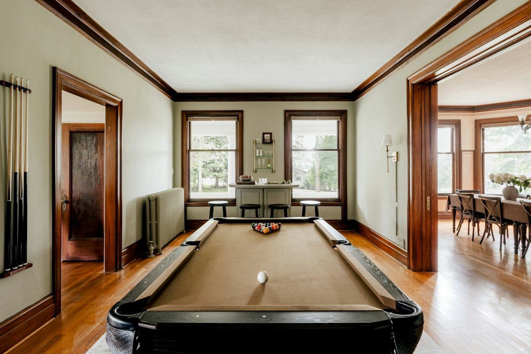Pool table in a finished home game room with space around the table