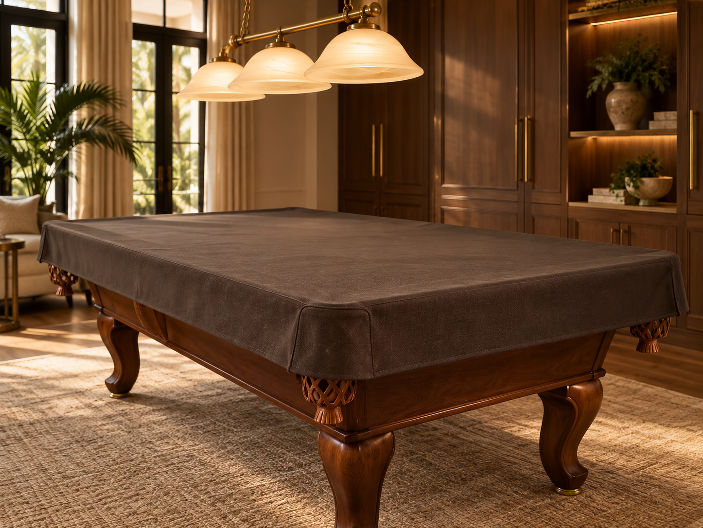 Fitted dark protective cover over a walnut pool table in a warm residential game room.