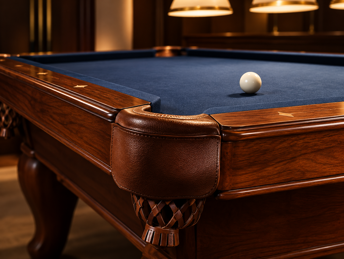 Close view of a leather corner pocket, walnut rail, blue billiard cloth, and cue ball.